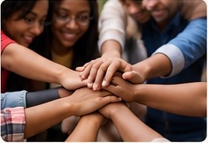 Many hands joined together in a circle.